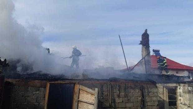 Un pompier și câțiva cetățeni au salvat o femeie din casa aflată în flăcări